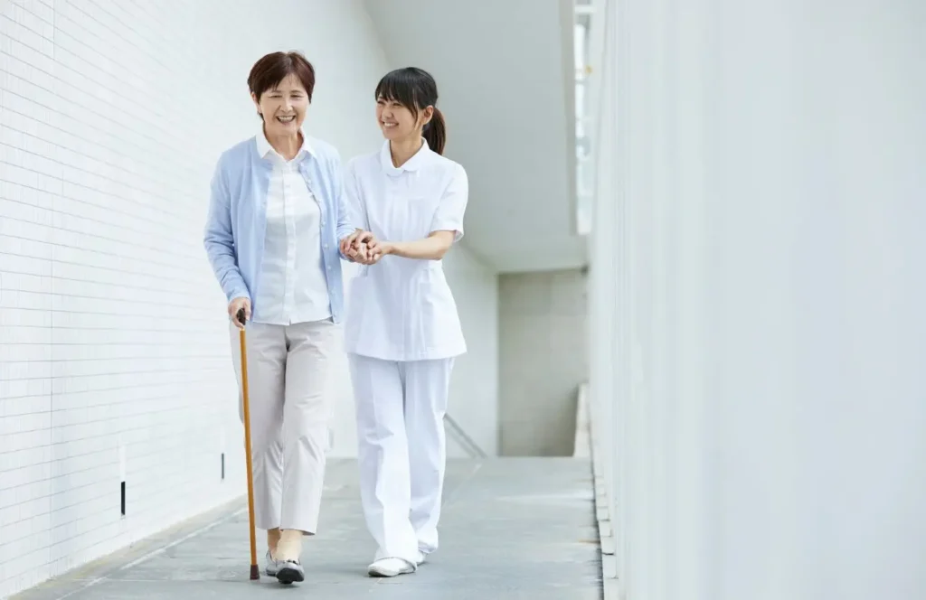 nurse assisting senior with walking support